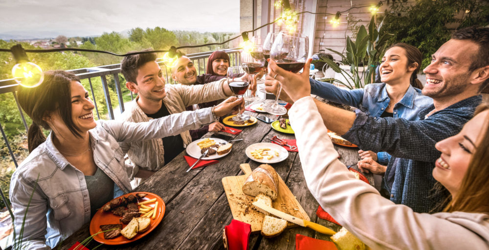 people enjoying dinner on outdoor living patio with garden